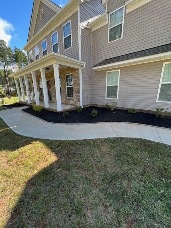 Curbed mulch bed along a concrete driveway